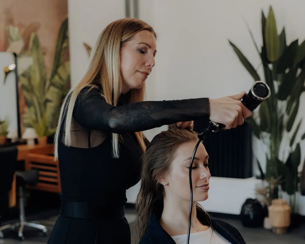 Friseurmeisterin Jasmin Werner föhnt bei einem Fotoshooting die Haare eines Models