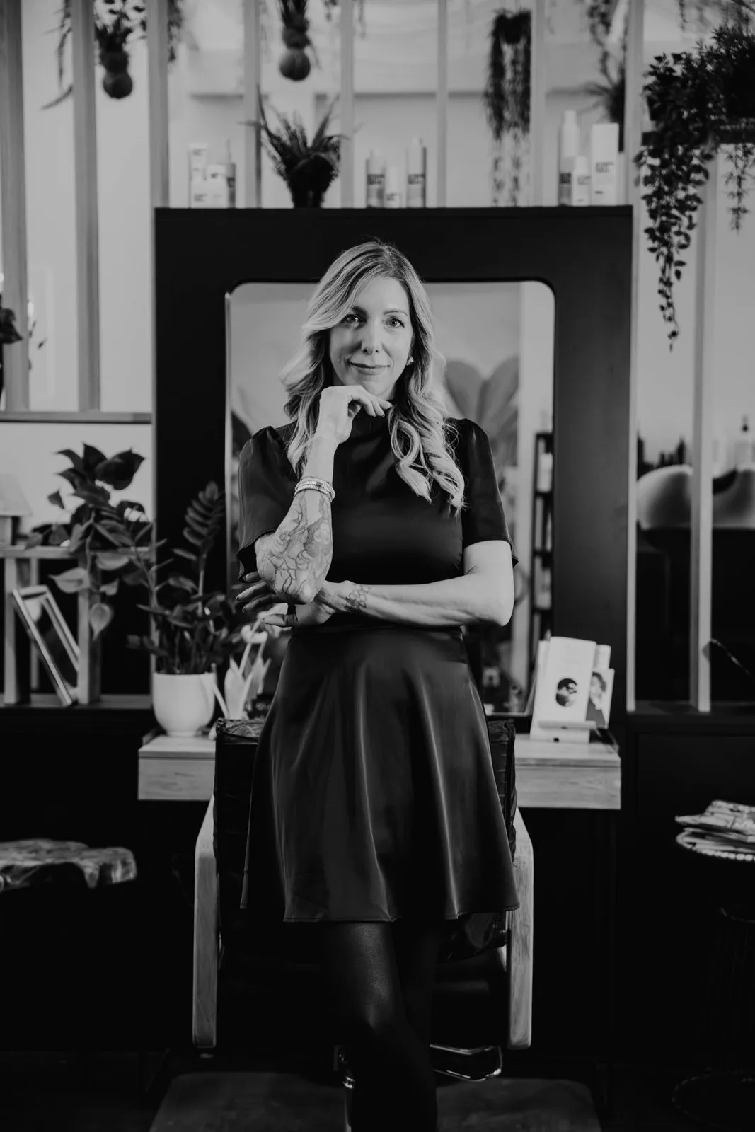 Jasmin Werner in Schwarz-Weiß, nachdenklich vor einem Spiegelplatz in ihrem Salon