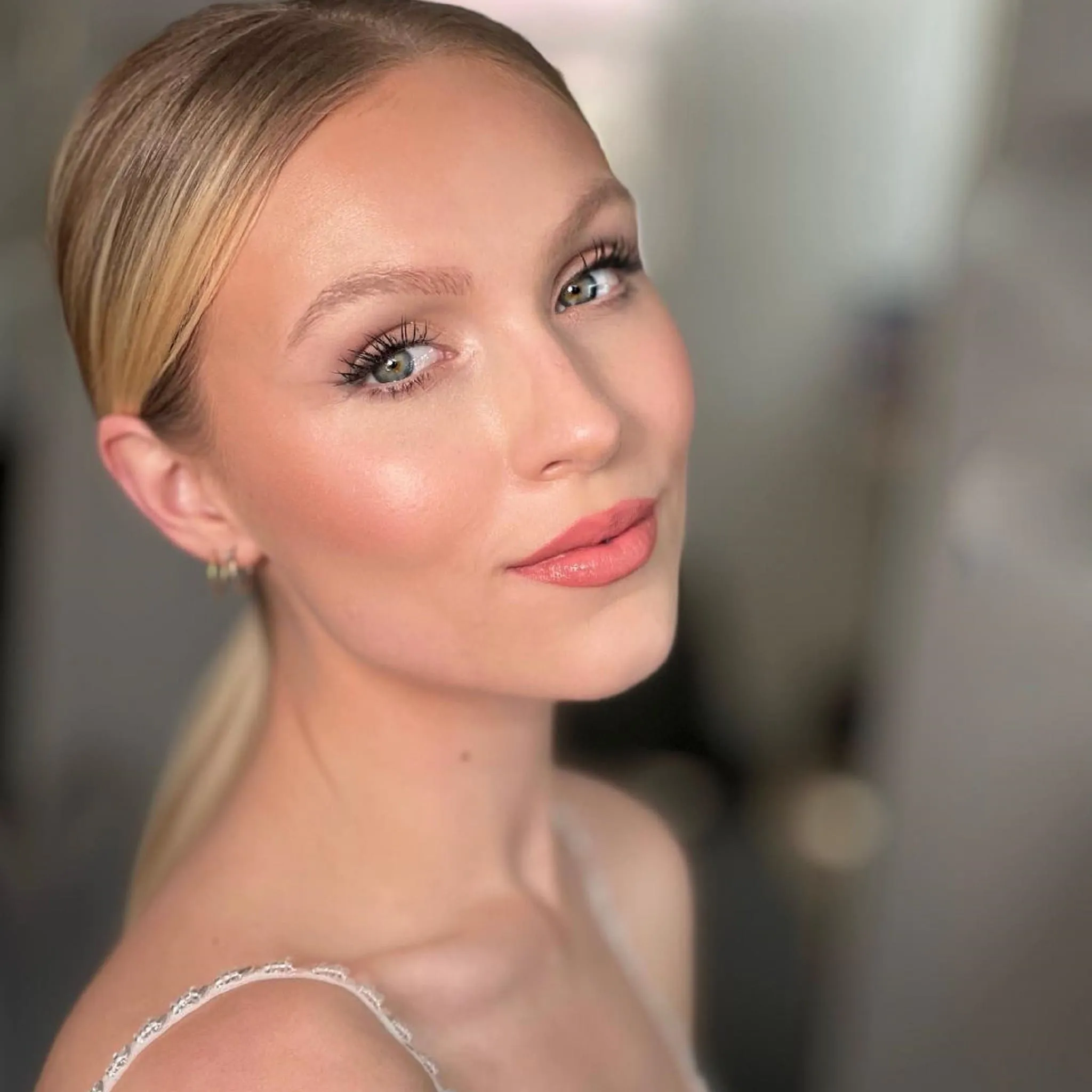 Bridal Make-up von Kristina Gasperas: frischer, natürlicher Look mit rosigen Wangen und Nude-Lippen, Blond mit glattem, tief sitzendem Pferdeschwanz