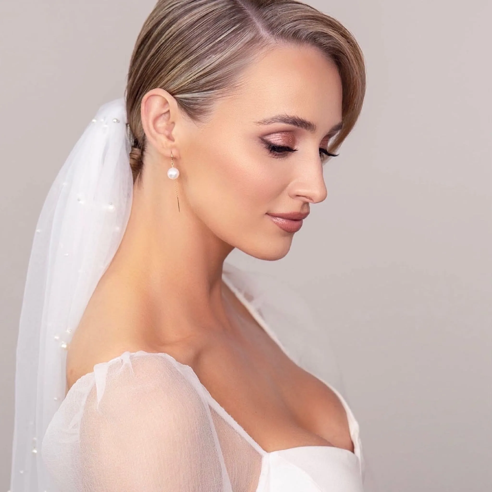 Bridal Make-up von Kristina Gasperas: Braut mit Perlenschleier im Profil, zarter Lidschatten in Rosé