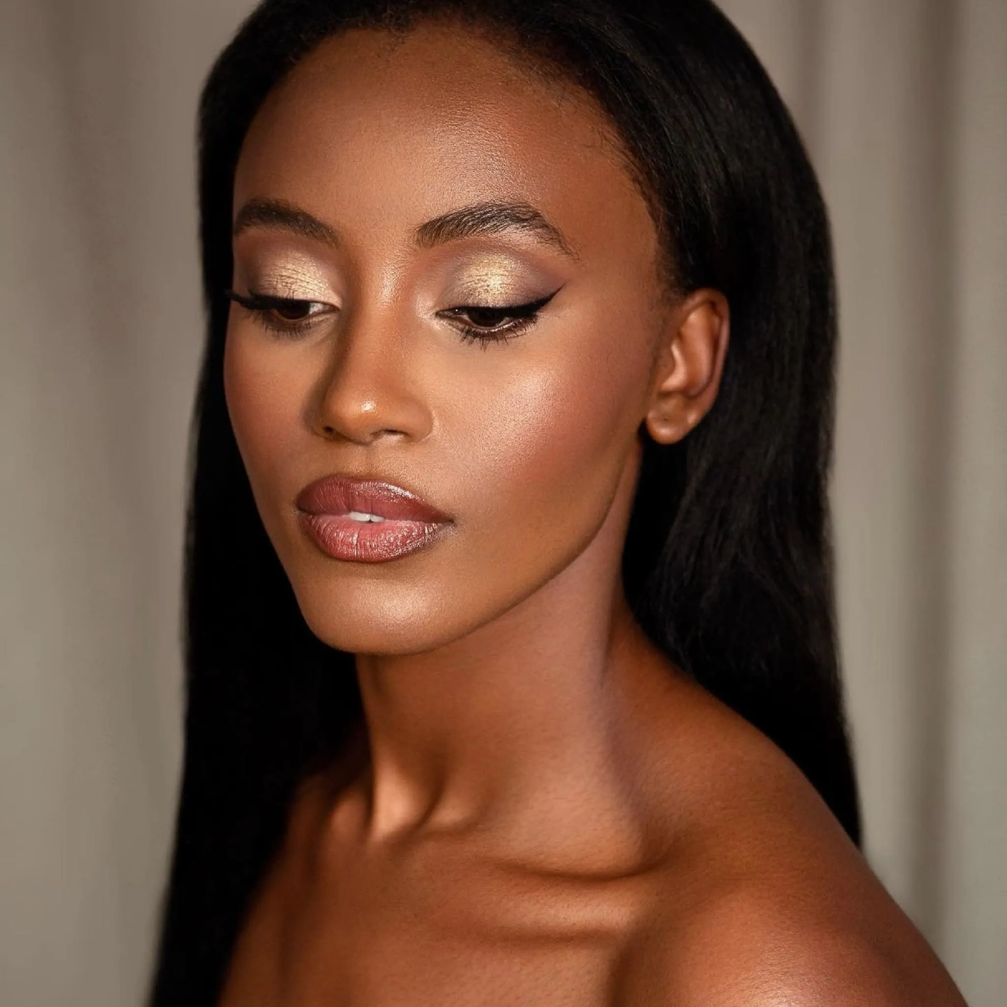 Bridal Make-up von Kristina Gasperas: goldener, schimmernder Augen-Look mit Eyeliner auf dunkler Haut