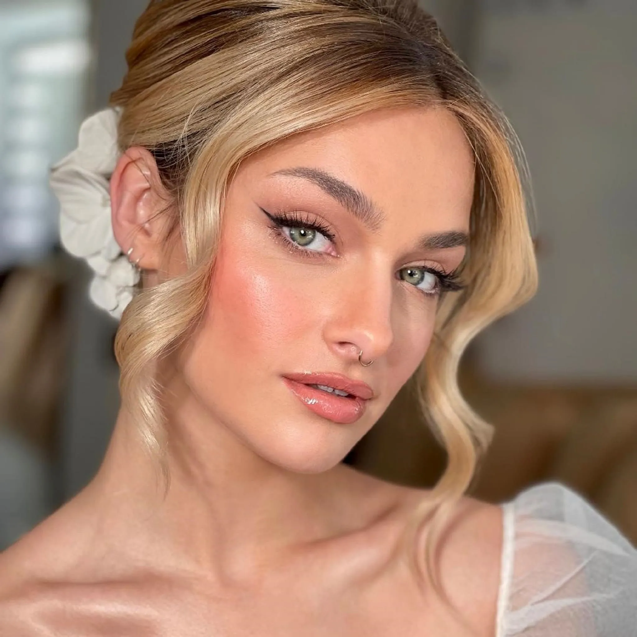 Bridal Make-up von Kristina Gasperas: Eyeliner und Pfirsich-Rouge, Blond mit Blütenspange und weichen Wellen