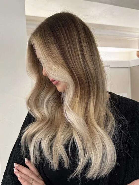 Langes blondes Haar mit weichem Balayage und gesetzten Face-Framing-Strähnen