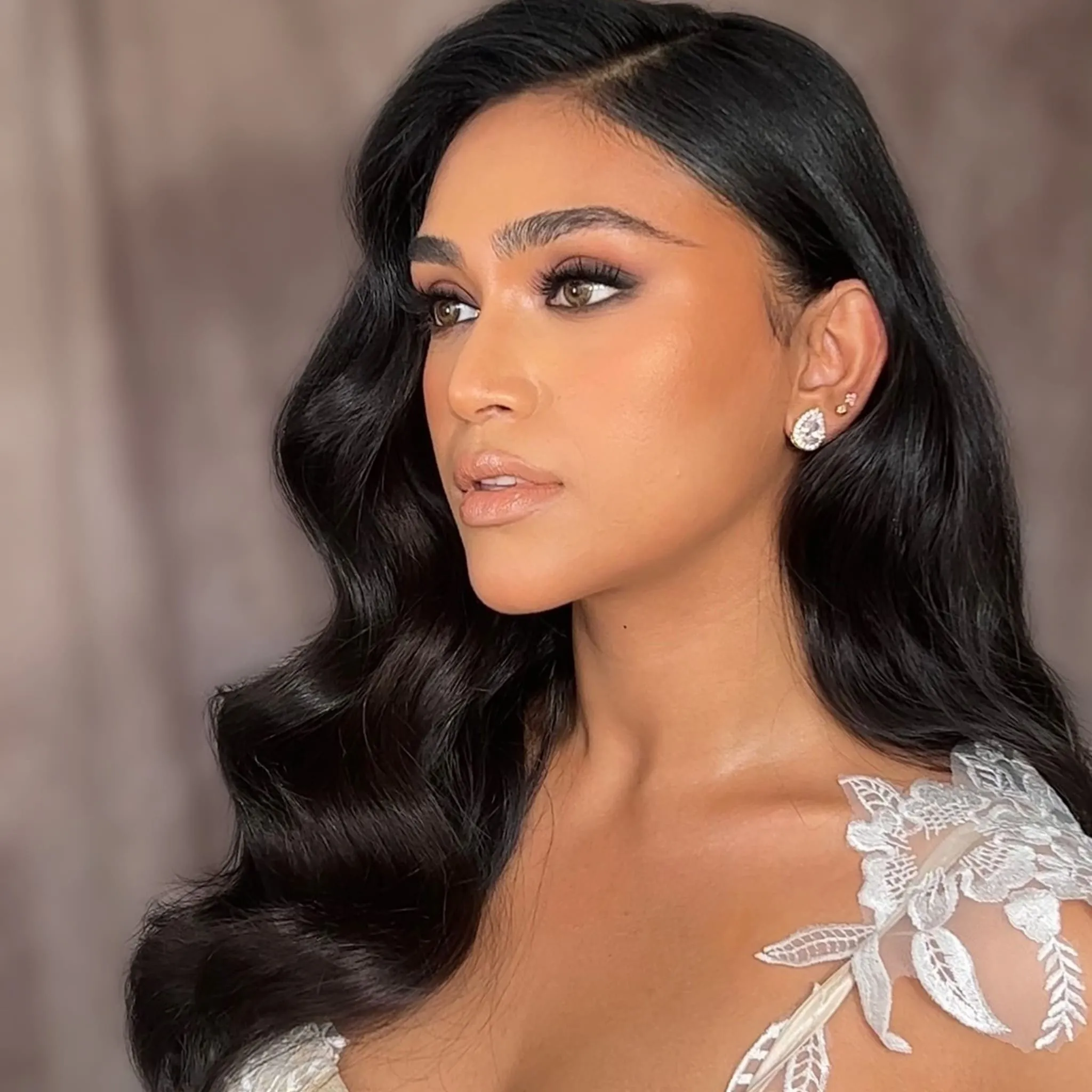 Bridal Look mit dunklen Hollywood Waves, strahlendem Make-up und Spitzenkleid